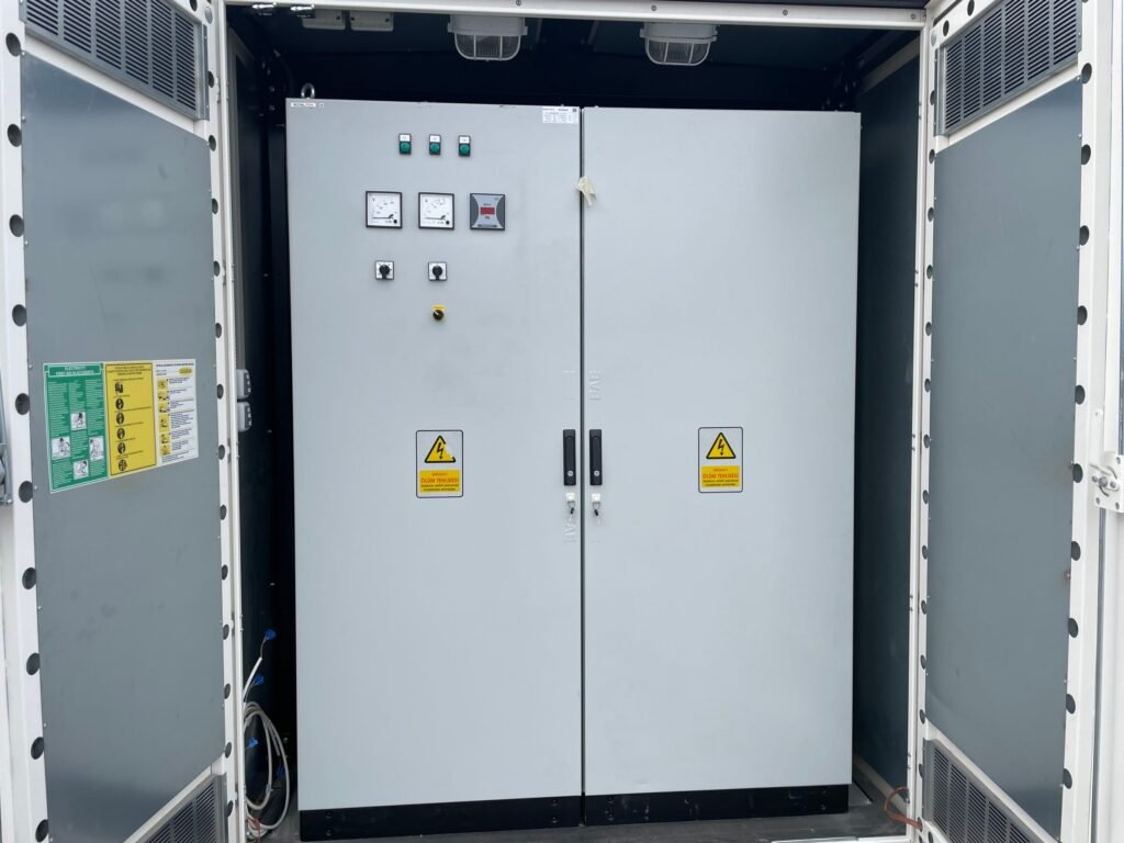 Custom-built two-door low-voltage distribution panel with meters and selector switches in the low-voltage compartment of a compact substation metal kiosk